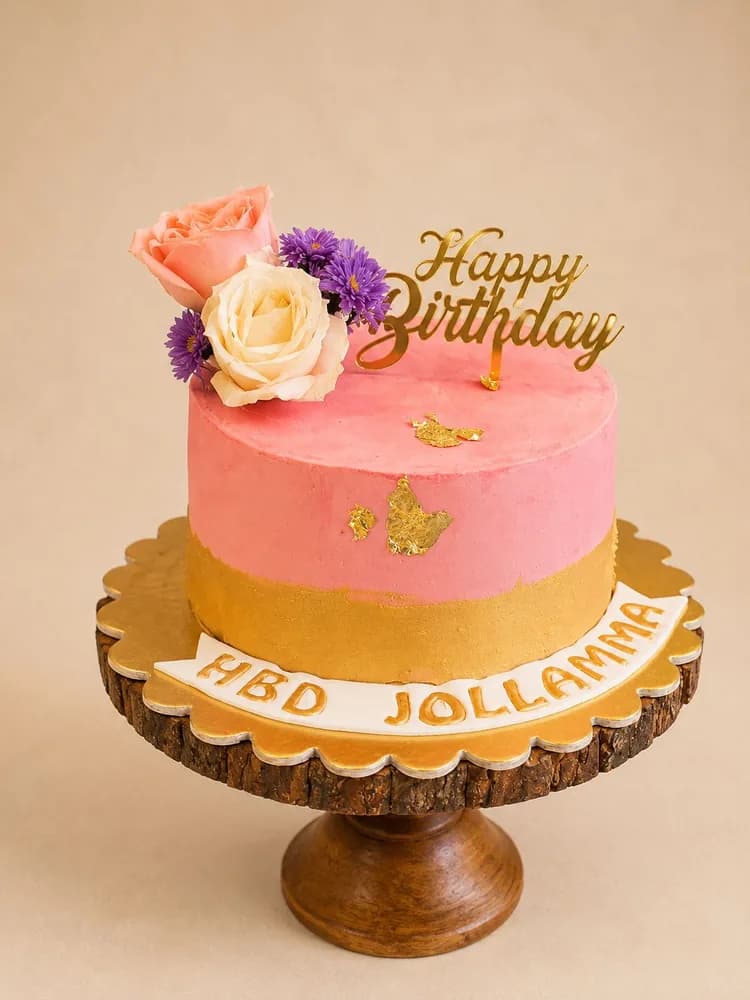Pink and gold cake topped with fresh roses